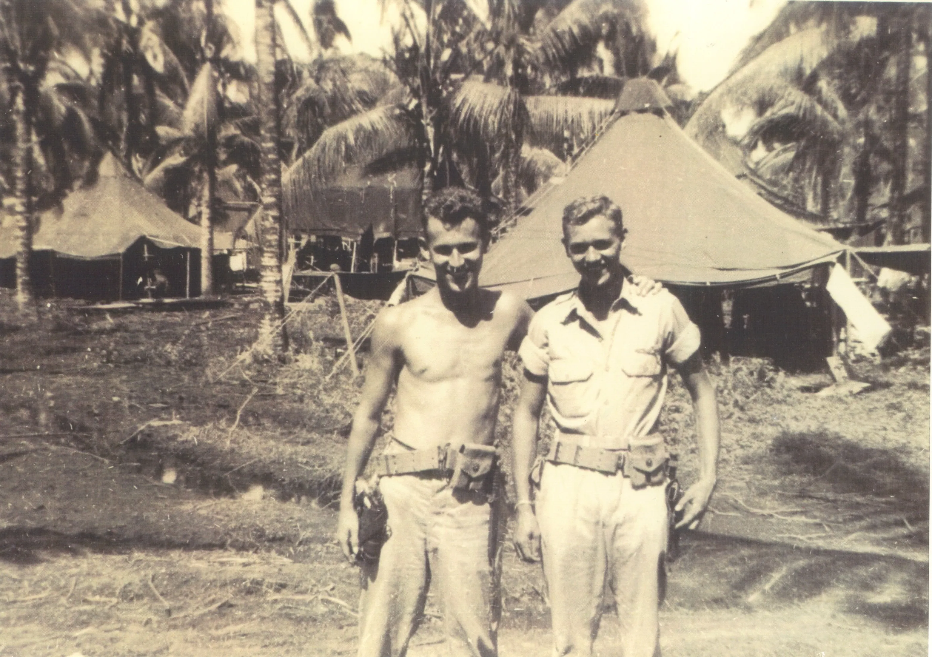 Robert Earl Wildermuth in front of palm trees, Pacific theater, c. 1944–1945