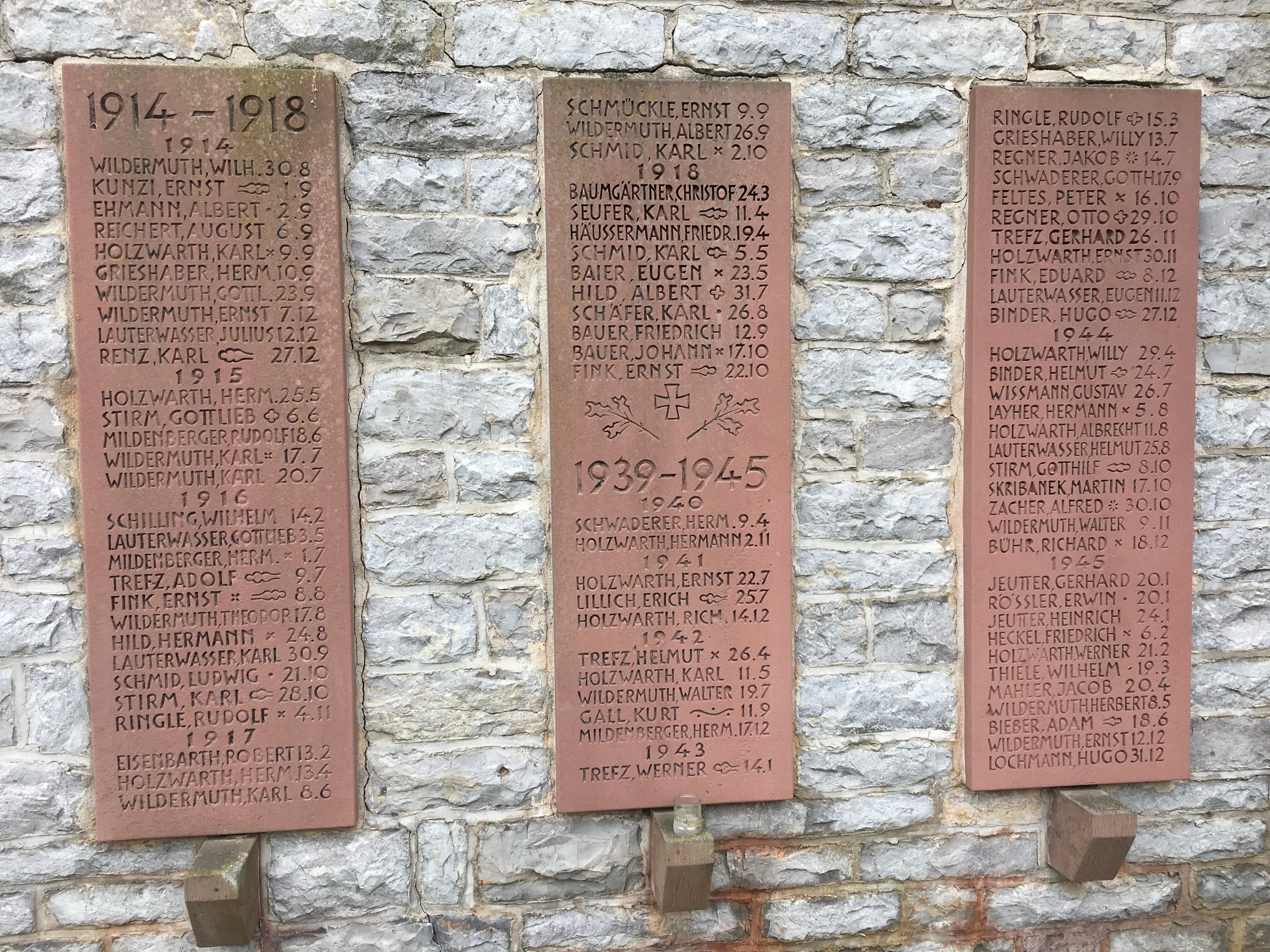 The three memorial tablets — 1914–18 on the left and right, 1939–45 in the center — the Wildermuth name recurring down each.
