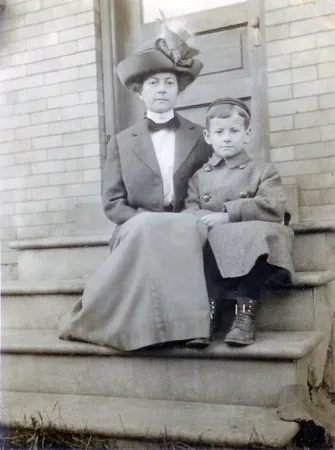 Alice Anderson McMaster on a porch step with her young son Donald A. McMaster, c. 1910–12, Pennsylvania. Alice wears a large feathered hat — the deck notes it is trimmed with a whole bird — and Don, in a wool coat and cap, sits solemnly beside her.
