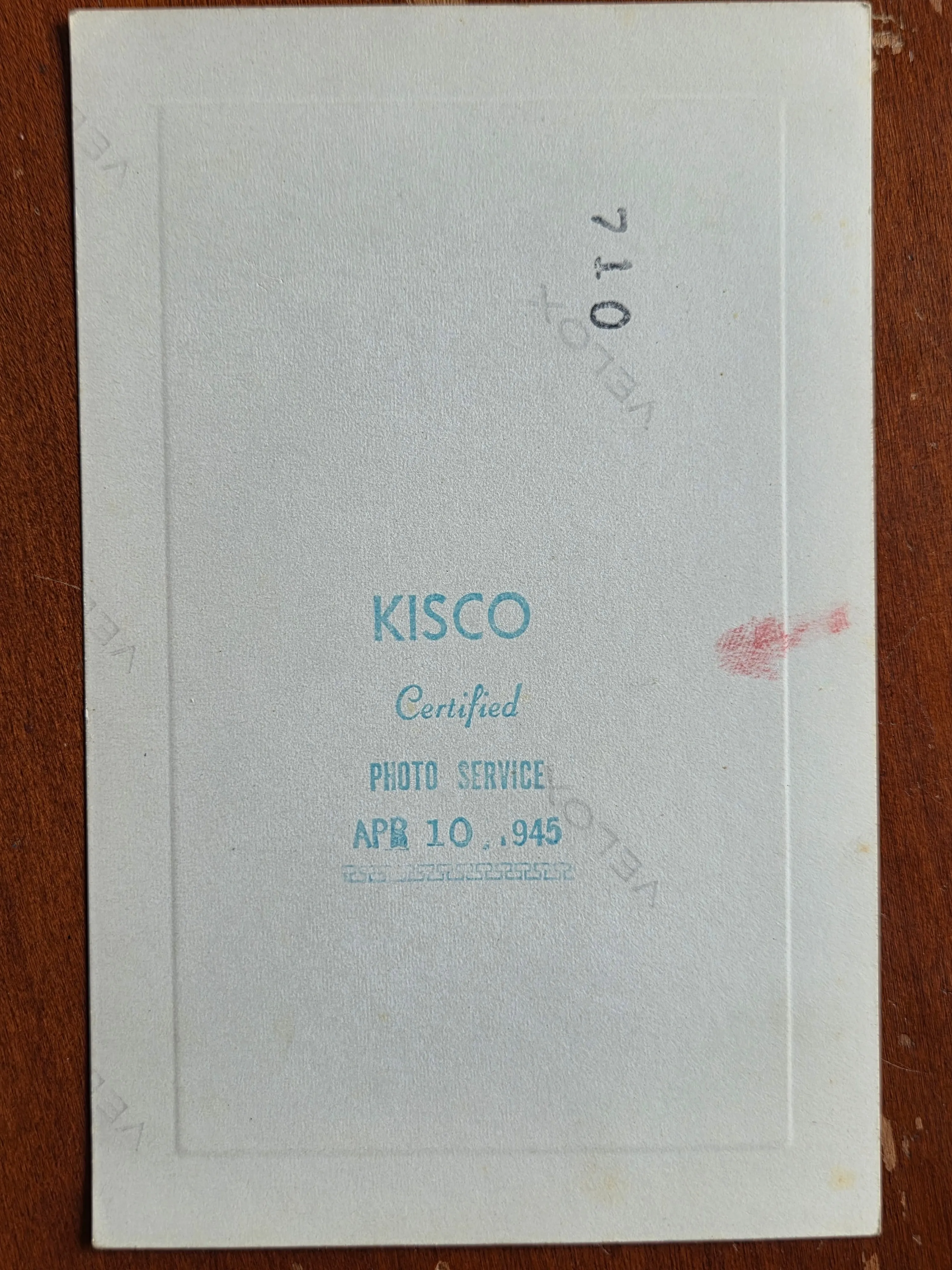 The back of the same photograph — a KISCO Certified Photo Service date stamp reading 10 April 1945, the source of the photo's date.