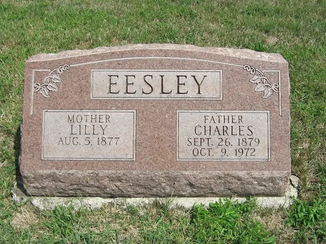 The shared rose-granite grave marker of Charles Leonard Eesley and his wife Lillie Dale (Chenoweth) Eesley — EESLEY carved across the top, MOTHER · LILLY · AUG. 5 1877 on the left panel and FATHER · CHARLES · SEPT. 26 1879 · OCT. 9 1972 on the right.