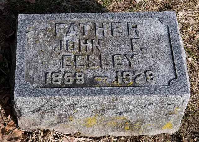The granite grave marker of John F. Eesley at Plainwell, Michigan, carved "FATHER / JOHN F. EESLEY / 1859–1929."
