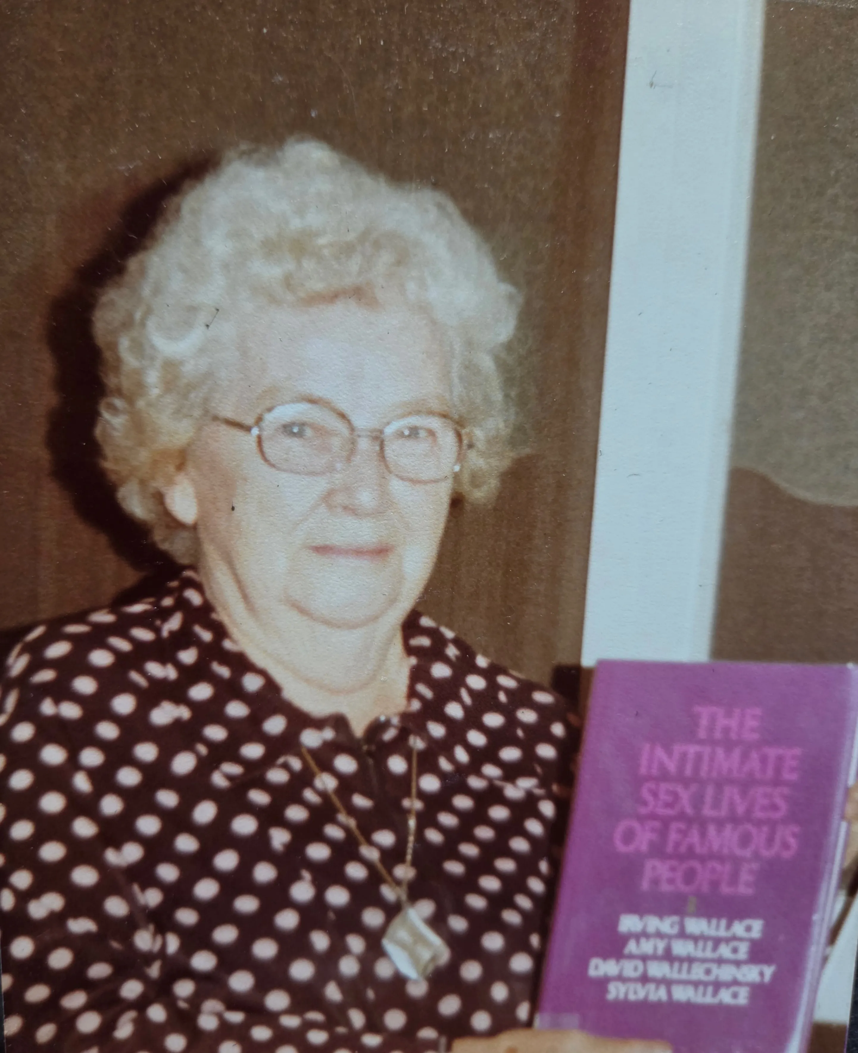 Mafry Smith Hyatt, c. 1981, holding up "The Intimate Sex Lives of Famous People" by Irving Wallace + family — Roberta Burnes Walker's favorite photo of her great-aunt Mafry.