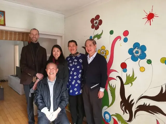 Zhou Zhaoxiang seated, with his daughter Ai Hua Zhou, granddaughter Lijie, and Chuck, at the same Qingdao visit.