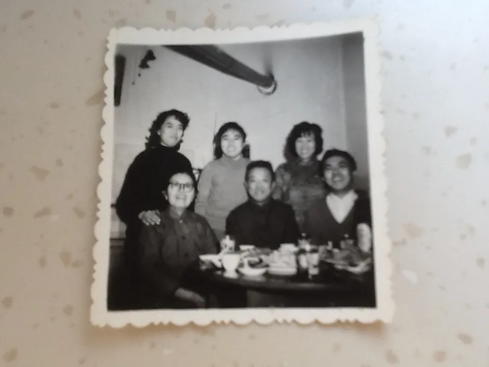 A second early black-and-white Zhou–Li family photograph, a group of four or five at a table, c. 1960s–70s.